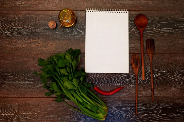 A place for advertising, ads or menu notebook lying on a wooden table next to the kitchen, wooden cutlery, olive oil