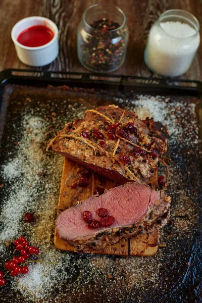 Cook the meat laid out on a baking sheet that apply to the table roasted lamb, all served with bright red berries