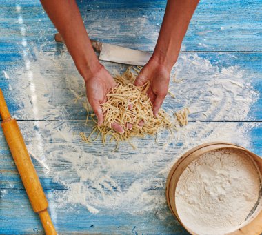 Cook ince hamur yoğurmak ve spagetti kesilmiş, satın alma yemek sosu ve karides ile