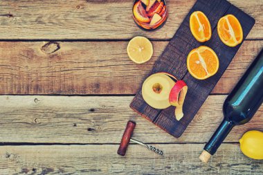 Bir şişe bir cam ve malzemeler ahşap rustik masaya eşliğinde sangria. Kırmızı şarap, portakal, limon ve elma. Geleneksel yaz içki içecek. Kopya alanı ile üstten görünüm.