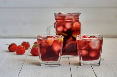İç. Şarap. Kavram. İspanya. İçecek kabı. Kırmızı şarap sangria veya yumruk meyve ve buz ile gözlük ve sürahi. Ev yapımı meyve sangria kopya alanı beyaz ahşap tablo yenileme.