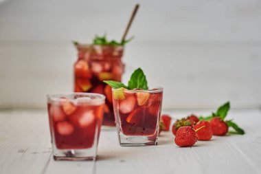 Ferahlatıcı sangria veya gözlük ve sürahi ile meyve punch. Geleneksel yaz içki içecek. Kırmızı şarap, çilek, portakal, limon ve yeşil elma. Bir ahşap rustik masaya kopya alanı ile