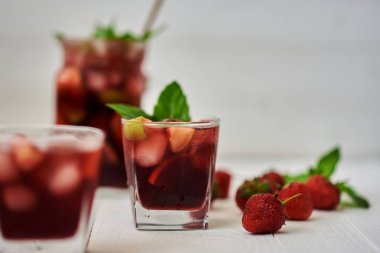 İç. Şarap. Kavram. İspanya. İçecek kabı. Kırmızı şarap sangria veya yumruk meyve ve buz ile gözlük ve sürahi. Ev yapımı meyve sangria kopya alanı beyaz ahşap tablo yenileme.