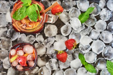 Bir sürahi ve bardak sangria, tipik bir İspanyol alkollü içki. Kırmızı sangria meyve ve buz ile. Geleneksel yaz ferahlatıcı içki, kokteyl. Buz küpleri arka plan kopya alanı ile üstten görünüm.