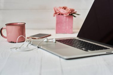 Kadınsı çalışma alanı - worksplace klavye, kahve ve çiçekler. Buket gül, fincan kahve ve eski ahşap masa üstünde laptop. Yaratıcı planlama kavramı. Üstten görünüm. Tonlu görüntü. Vintage tarzı.