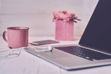 Kadınsı çalışma alanı - worksplace klavye, kahve ve çiçekler. Buket gül, fincan kahve ve eski ahşap masa üstünde laptop. Yaratıcı planlama kavramı. Üstten görünüm. Tonlu görüntü. Vintage tarzı.