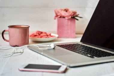 Kadınsı çalışma alanı - worksplace klavye, kahve ve çiçekler. Buket gül, fincan kahve ve eski ahşap masa üstünde laptop. Yaratıcı planlama kavramı. Üstten görünüm. Tonlu görüntü. Vintage tarzı.