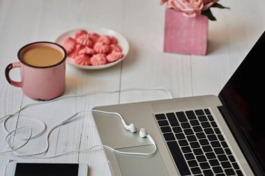 Kadınsı çalışma alanı - worksplace klavye, kahve ve çiçekler. Buket gül, fincan kahve ve eski ahşap masa üstünde laptop. Yaratıcı planlama kavramı. Üstten görünüm. Tonlu görüntü. Vintage tarzı.