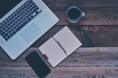 Vintage Danışma dizüstü bilgisayar, gözüne gözlük, smartphone, kalem ve bir fincan kahve, en iyi görünüm. Boş dizüstü bazı metin veya resim koymak için kullanılabilir. İş kavramı kopya alanı ile. Vintage tarzı.
