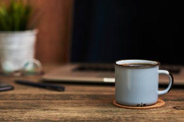 Çalışma alanı ile yakından fincan kahve, ofis malzemeleri ve dizüstü bilgisayar içinde belgili tanımlık geçmiş. Boş ekran bazı metin veya resim koymak için kullanılabilir. İş kavramı kopya alanı ile. Vintage tarzı