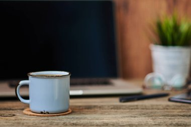 Çalışma alanı ile yakından fincan kahve, ofis malzemeleri ve dizüstü bilgisayar içinde belgili tanımlık geçmiş. Boş ekran bazı metin veya resim koymak için kullanılabilir. İş kavramı kopya alanı ile. Vintage tarzı