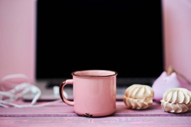 Kadınsı işyeri. Closeup bardak sıcak çikolata, dizüstü bilgisayar ve çiçekler arka planda worksplace. Eski ahşap masa üzerinde rahat çalışma alanı. Yaratıcı planlama kavramı. Vintage tarzı. Seçici odak.