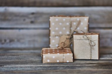 El yapımı hediye kutuları Eko dostu craft kağıdına sarılmış ve ahşap antika arka plan üzerinde sicim ile bağlı. Tasarımınız için arka plan. Tatil ambalaj kavram. Metin için yer kopyalayın.