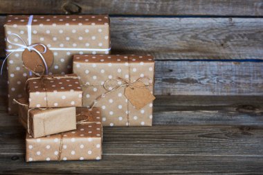 El yapımı hediye kutuları Eko dostu craft kağıdına sarılmış ve ahşap antika arka plan üzerinde sicim ile bağlı. Tasarımınız için arka plan. Tatil ambalaj kavram. Metin için yer kopyalayın. Seçici odak