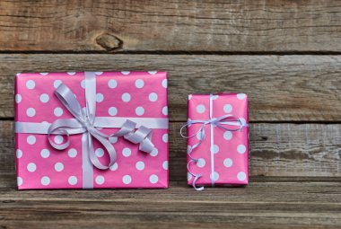 İki güzel, pembe lekeli beyaz kurdele yılbaşı, Sevgililer günü, Doğum günü veya anneler günü tebrik için kutuları hediye. El yapımı hediye kutuları beyaz vintage ahşap zemin üzerinde. Kopya alanı ile üstten görünüm.