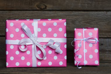 İki güzel, pembe lekeli beyaz kurdele yılbaşı, Sevgililer günü, Doğum günü veya anneler günü tebrik için kutuları hediye. El yapımı hediye kutuları beyaz vintage ahşap zemin üzerinde. Kopya alanı ile üstten görünüm.