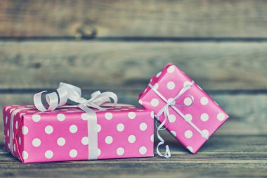 İki güzel, pembe lekeli beyaz kurdele yılbaşı, Sevgililer günü, Doğum günü veya anneler günü tebrik için kutuları hediye. Rustik ahşap arka plan olarak el yapımı hediye kutuları. Vintage tarzı. Tatil ambalaj.