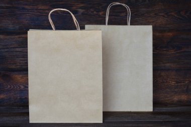 Mockup boş alışveriş torbaları. Kahverengi zanaat paketleri. Satış veya indirimler için kavram. Geri dönüşümlü kağıt. Ahşap rustik tahtası.