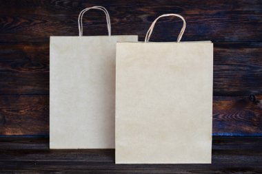 Satılık, tüketim ve reklam kavramı - vintage ahşap tahta arka plan üzerinde boş kahverengi kağıt torba.