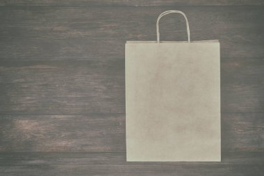 Mock-up kahverengi craft kağıt paket kulplu, boş alışveriş çantası için logo veya tasarım, ahşap tahta arka plan, gıda dağıtım, satış, tüketim ve reklam kavramı bulunduðu.