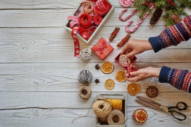 Eller bir Noel hediyesi ahşap arka plan üzerinde kaydırma. Kopya alanı ile üstten görünüm.