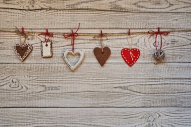 Kırmızı ve beyaz Noel arka plan beyaz ahşap arka plan önünde, ipte asılı Noel süsleri kalpler.