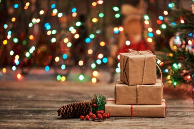 Noel ve yılbaşı ağacı süsleri arka plan. El yapımı hediye kutuları eski ahşap tablo.