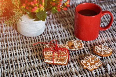 Çeşitli Noel gingerbread çerezleri cam eski beyaz hasır masada krema ile.