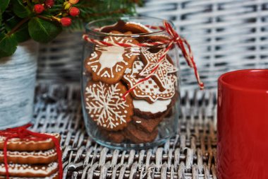 Eski beyaz hasır arka plan üzerinde cam kavanoza Noel kurabiyeleri.