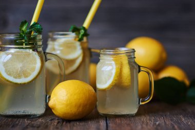 Nane ve buz ile ev yapımı limonata. Mason limonata rustik ahşap arka plan üzerinde kavanozları. Lezzetli ve sulu limonata, yararlı vitaminler ve antioksidanlar dolu. Sağlıklı ve detoks yaz içeceği.