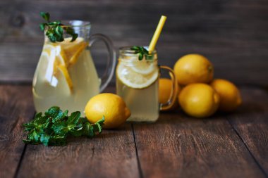 Nane ve sürahi, ahşap arka plan üzerinde taze limon ile buz ile ev yapımı limonata. Lezzetli ve sulu limonata, yararlı vitaminler ve antioksidanlar dolu. Sağlıklı ve detoks yaz içeceği.
