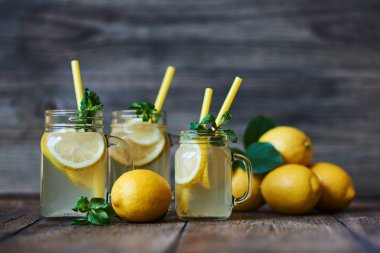 Nane ve buz ile ev yapımı limonata. Mason limonata rustik ahşap arka plan üzerinde kavanozları. Lezzetli ve sulu limonata, yararlı vitaminler ve antioksidanlar dolu. Sağlıklı ve detoks yaz içeceği.