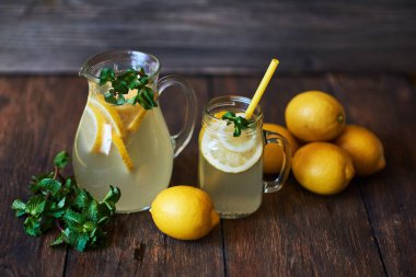 Nane ve sürahi, ahşap arka plan üzerinde taze limon ile buz ile ev yapımı limonata. Lezzetli ve sulu limonata, yararlı vitaminler ve antioksidanlar dolu. Sağlıklı ve detoks yaz içeceği.