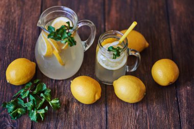 Nane ve sürahi, ahşap arka plan üzerinde taze limon ile buz ile ev yapımı limonata. Lezzetli ve sulu limonata, yararlı vitaminler ve antioksidanlar dolu. Sağlıklı ve detoks yaz içeceği.