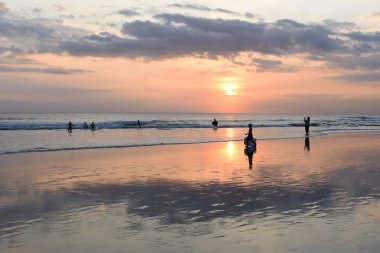 Günbatımında sörf tahtaları çocukla siluet.
