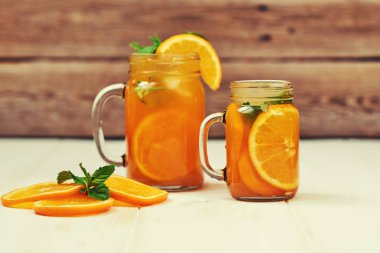 Bardak taze sıkılmış portakal suyu-portakal ahşap masa üzerinde arka plan üzerinde.