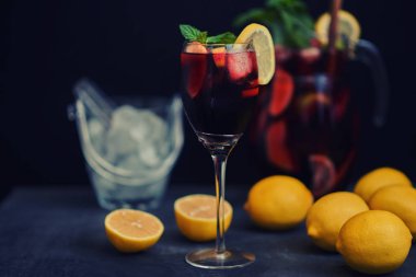 Sangria ve malzemeler. Ferahlatıcı sangria veya meyve ile yumruk şarap bardakları ve sürahi. Kırmızı şarap sangria buz ile. Tradbcional İspanyol sangria rustik ahşap masa, kopya alanı üzerinde.