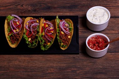 Baharatlı tavuk biftek ve cips tepsi ekşi krema ve salsa yakın yalan içinde taze sebze ile ulusal Meksika çanak ahşap masa üzerinde duran soslar