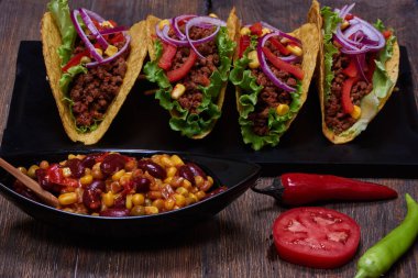 Domates, yeşil salata, mor soğan ve karanlık tra Mısır kırmızı taşlarla lezzetli cips tortilla cips içinde closeup görüntü