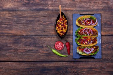 Farklı malzemeler kırmızı, yeşil biber yakın mavi tepsisindeki yalan ve kase mısır ve fasulye baharatlı sos ile geleneksel yemek pişmiş