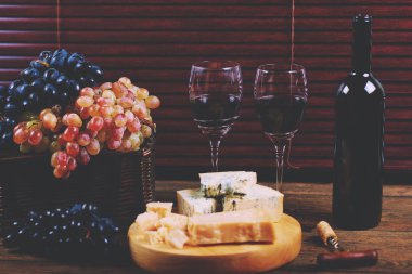 Hasır sepet ayakta Şarküteri küflü peynir tabağı üzerinde yakın şarap degustatio için düzenlenen üzüm koyu mavi ve hafif demet