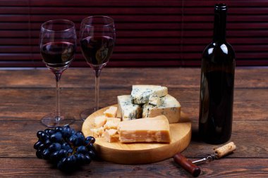 Yumuşak alkol içecek delicateness camembert peyniri ve doğal Olgun üzüm ile bir şişe. Köylü stilinde lezzetli yemekler ve frui ile şarap tadım