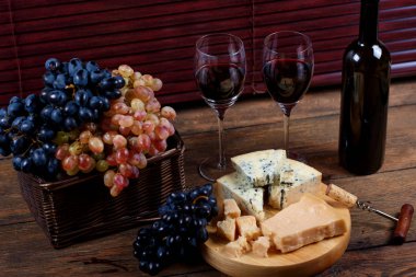 Danablu Şarküteri peynir kırmızı kuru sauvignon bardaklarda yakın tabakta keyifli dinne için rustik tarzı retro ahşap masa üzerinde duran yalan