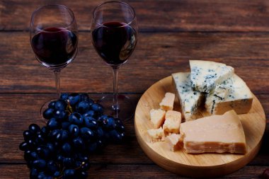 Portre resim delicateness peyniri dilimleri olgun sağlıklı üzüm demet yanındaki tabakta yalan. Foo ile köylü stilinde lezzetli alkol içecek