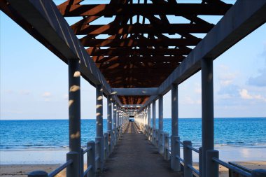 Okyanus ufukta çelik iskelede sonsuzluğa bakış açısı. Tropik sahil iskelede taşıma.