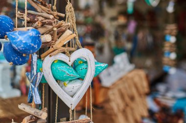 El yapımı ahşap Hediyelik eşya yıpranmış doğal doku ile oyulmuş. Renkli hediyeler, tatil güzel anılar. Sanat ve el sanatları pazarında Hatıra Eşyası. Seçici odak ve kopya alanı ile arka plan bulanık.