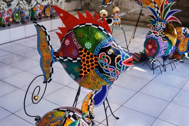 Ekran renkli el sanatları dekorasyon açık piyasada. Turist piyasada desenli el yapımı metal balık ile parlak renkli. Dükkanda görüntülenen çeşitli aletler ve otomotik makinalar. Hatıra Eşyası satışı