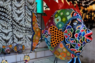 Ekran renkli el sanatları dekorasyon açık piyasada. Turist piyasada desenli el yapımı metal balık ile parlak renkli. Dükkanda görüntülenen çeşitli aletler ve otomotik makinalar. Hatıra Eşyası satışı