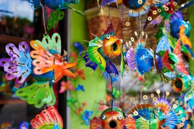 Renkli Hatıra arka plan. Asılı dekorasyon içinde belgili tanımlık çarşı. El yapımı metal balık turist piyasada asılı. Hatıra Eşyası satışı. Desenli komik el yapımı balıklarla parlak renkli.