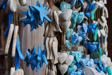 Seyahat ve Turizm kavramı. Birçok farklı seyahat Hatıra Eşyası. Dekoratif renkli ahşap oyma kalpleri ve yıpranmış doğal doku ile yıldız. Sanat ve el sanatları pazarında Hatıra Eşyası. Seçici odak.